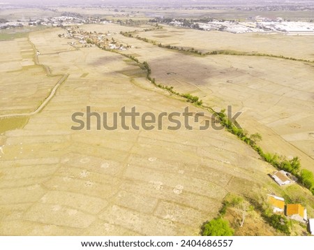 Industrial Photography Landscapes. Aerial view of dry rice fields after the harvest period ends, Located in Rancaekek, Bandung - Indonesia. Aerial Shot from a flying drone.
