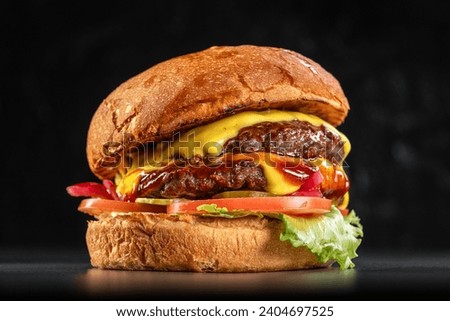 Delicious double cheeseburger with American cheese, lettuce, tomato, red onion, pickles, and farmhouse bun close up on a black background. Delicious cheeseburger. sandwich fast food, amazing food Royalty-Free Stock Photo #2404697525