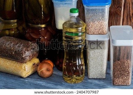 Food supplies for the period of quarantine isolation. Various glass jars with cereals, pasta, cans of canned food Royalty-Free Stock Photo #2404707987