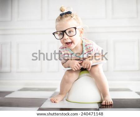Little girl on white potty with digital tablet  Royalty-Free Stock Photo #240471148