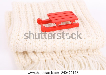 red wooden sledge christmas souvenir on the white scarf 