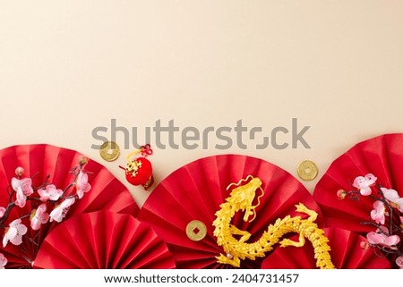 Let's rejoice and celebrate Chinese New Year. Top view flat lay of gold dragon, red paper fans, gold coins, decorative items, sakura bloom on beige background with promo zone Royalty-Free Stock Photo #2404731457