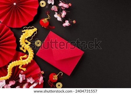 Cultural significance in Chinese New Year gift-giving. Top view shot of gold dragon, red featuring fans, envelope, sakura bloom, lucky coins on black background with promo area