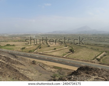 Mountain road with electric lighting poles in the morning on an autumn day In the city of Al-Hajra in the Al-Bahah region, southern Saudi Arabia