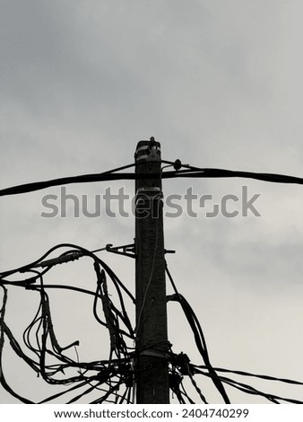 Urban connectivity captured in developing country. Electricity pole and cables stand tall against the sky, showcasing the intricate web of infrastructure that powers our modern world.