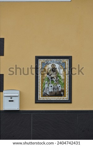 at the entrance to the building is a ceramic picture of religious content