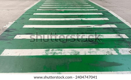Green and white zebra crossing as a traffic crossing sign on a public road