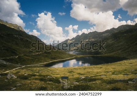 Alpine lake in the mountains. Clouds in the sky, warm colours.