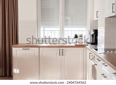 Interior of kitchen and dining room, white kitchen cabinetry and steel appliances. Interior photography. Open space living room with kitchen