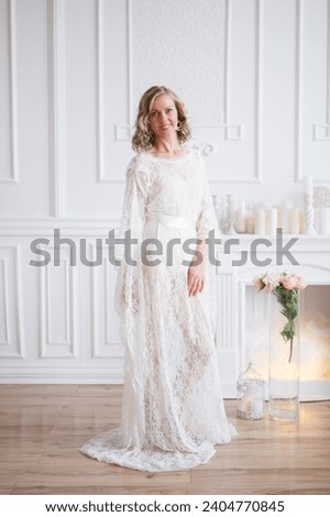 A beautiful woman is standing in a long lace dress 