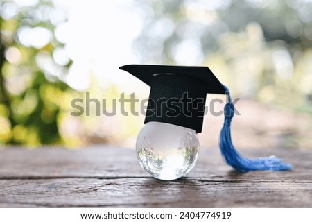 close up glass globe with graduation hat on wood table, world health day, medical education wallpaper background concept