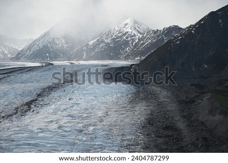 The glaciers of the Alaska mountains are enormous and are formed from melting snow, which sublimes in the mountains and gradually forms ice covering Royalty-Free Stock Photo #2404787299
