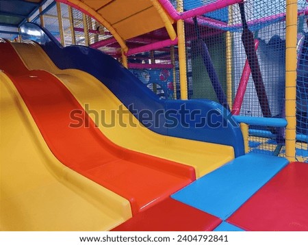 Playground entrance to the labyrinth with colorful tunnel and bridges, slides, children's room in play Entertainment center. Floor net steps to trampoline. Banner active leisure, free time kids photo Royalty-Free Stock Photo #2404792841