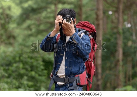 Backpacker carrying bags in forest and mountains