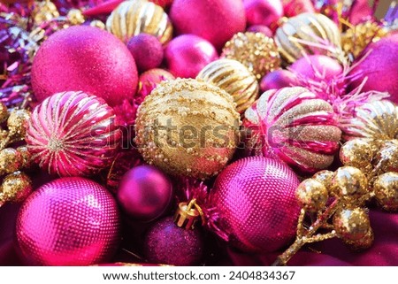 New Year's Christmas balls, tinsel and decorations close up. Decorations of golden, pink, lilac, purple, violet. Striped Christmas balls. Festive beautiful colorful background. Home holidays design