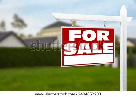 Sale sign near beautiful house outdoors. Red signboard with words