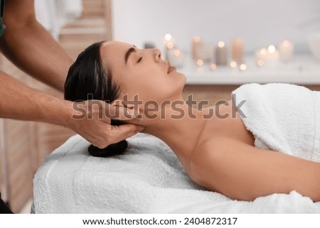 Woman receiving professional neck massage on couch in spa salon