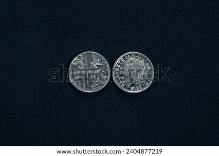 Two-sided five pence coin on black background.