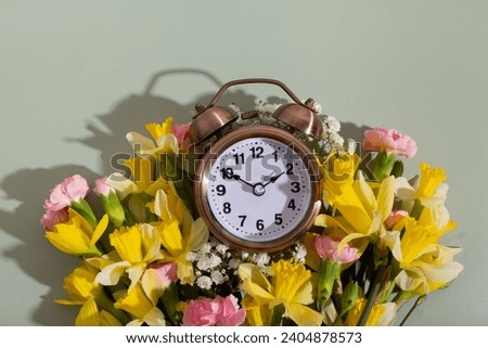 Alarm clock with spring flowers. Spring time, daylight savings concept, spring forward.