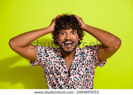 Photo portrait of handsome young guy arms touch head excited crazy dressed stylish leopard print outfit isolated on yellow color background