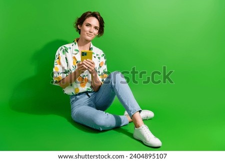 Full body size photo of young funny charming blogger girl shopaholic using smartphone for commerce isolated on green color background
