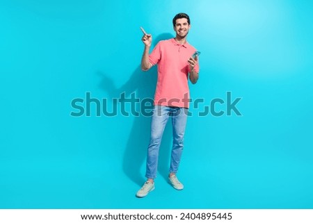 Full body size photo of successful guy solve business tasks remote direct finger empty space using phone isolated on blue color background