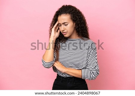 Young hispanic woman isolated on pink background with headache