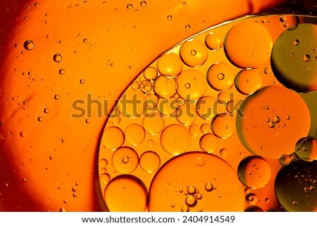 Orange drops of oil or serum texture background. Oil drops on the water's surface. Macro photography	 Royalty-Free Stock Photo #2404914549