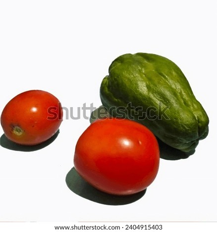 one chayote and two red tomatoes on a white background
