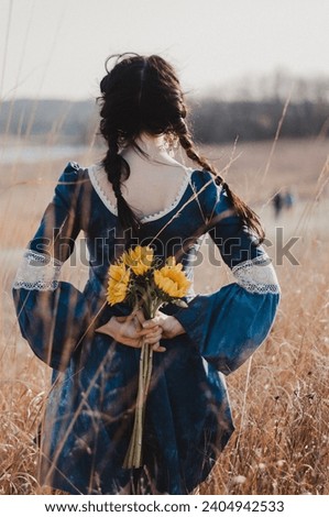 woman in a field holding flowers, editorial portrait photography, happy