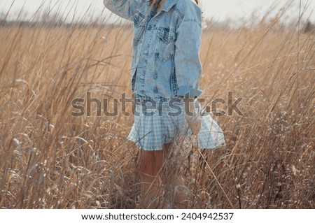 woman in a field holding flowers, editorial portrait photography, happy