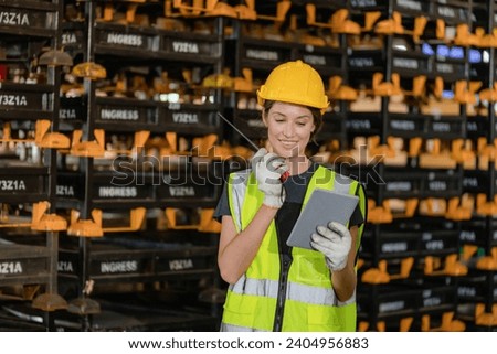Professional Female Worker Wearing Hard Hat Checks Stock and Inventory with Digital Tablet Computer in the Retail Warehouse full of Shelves with Goods. People Working in Logistics Distribution Center