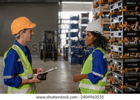 Portrait of warehouse team discussing work in a warehouse. Workers are checking stock with the digital logistics center safety vests to work on shipment in-store.