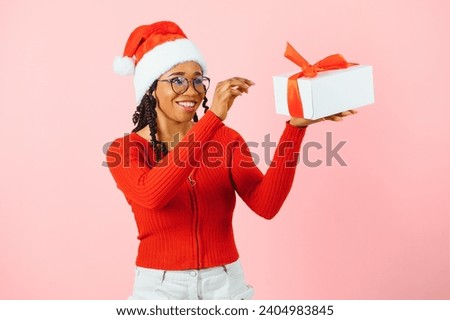 Guess What's Inside. Happy black woman in red sweater shaking present.