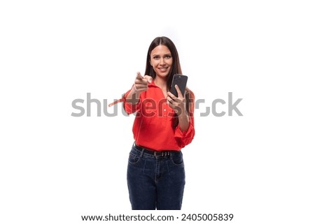young successful brunette assistant woman dressed in a red blouse uses the phone on a white background with copy space Royalty-Free Stock Photo #2405005839