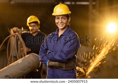 Portrait of woman engineer standing and looking camera in  factory.