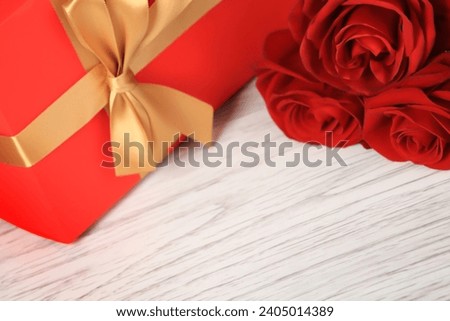 Beautiful roses and gift box, Gift box on a wooden background, Valentine's Day gift, selective focus, holiday. 