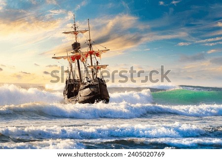 Grand view of an old sailing ship from the times of pirates and the Middle Ages on the high seas with big waves and with a beautiful sky Royalty-Free Stock Photo #2405020769