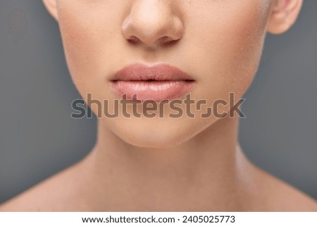 close up of young woman with juicy lips and perfect skin posing on grey background, youth and beauty Royalty-Free Stock Photo #2405025773