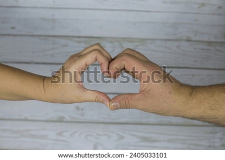 Senior male and female hand depict a heart. Symbol of love from adults in a happy marriage. Close photo of hands