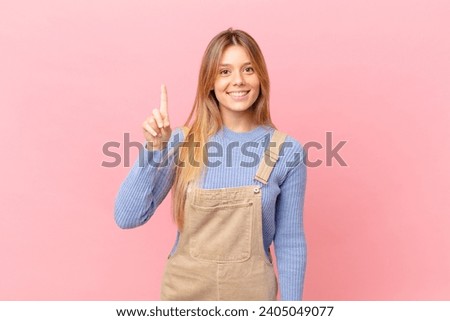 young woman smiling and looking friendly, showing number one