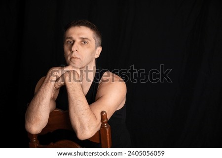 Man posing on a black background in a room
