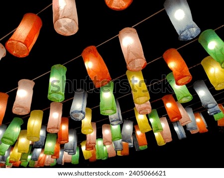Floating lanterns or colorful lanterns for decorating festivals are made from colorful paper on a dark background.