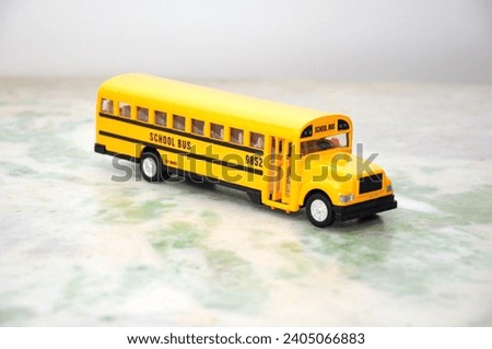 
American school bus miniature in standard yellow color with view of the entrance door