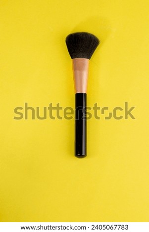 Makeup brush on yellow background Royalty-Free Stock Photo #2405067783