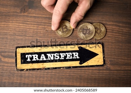 Bitcoin Transfer concept. Direction arrow with text on wood texture background.