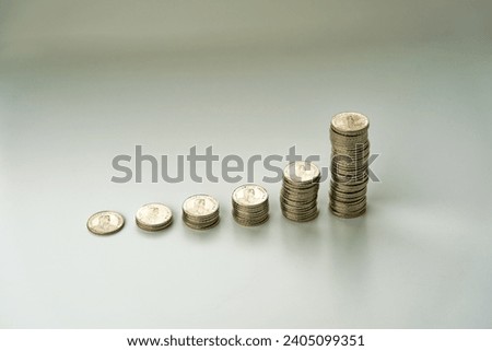 Scenic close-up view of piles of stapled gray metal five Swiss francs coins against white background. Photo taken December 26th, 2023, Zurich, Switzerland.