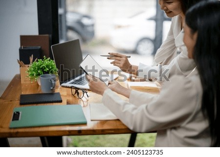 Close up of two businesswomen working using digital tablets Consult and plan together. Brainstorm, share and discuss business project ideas.