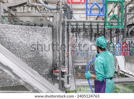 Worker disinfecting interior of a butchery in poultry factory.
