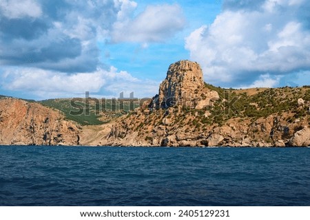 Mountain high cliff in the sea with clouds in the sky Royalty-Free Stock Photo #2405129231